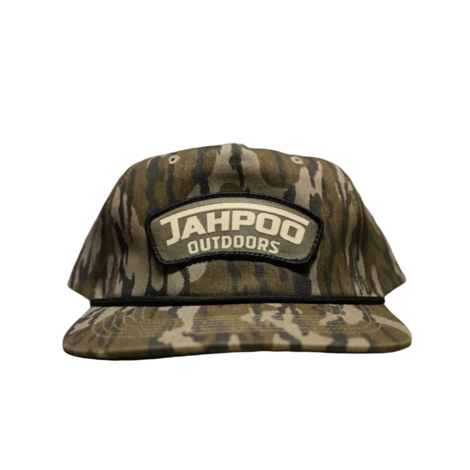 A camouflage baseball cap with a prominent 'JAHPOO OUTDOORS' patch on the front, displayed on a beige surface against a gray brick wall background.